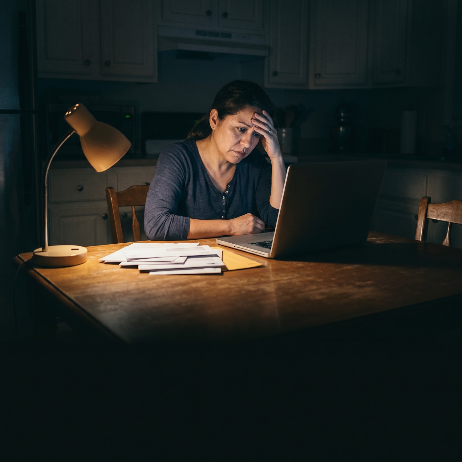 Madre preocupada revisando cuentas y facturas por la noche